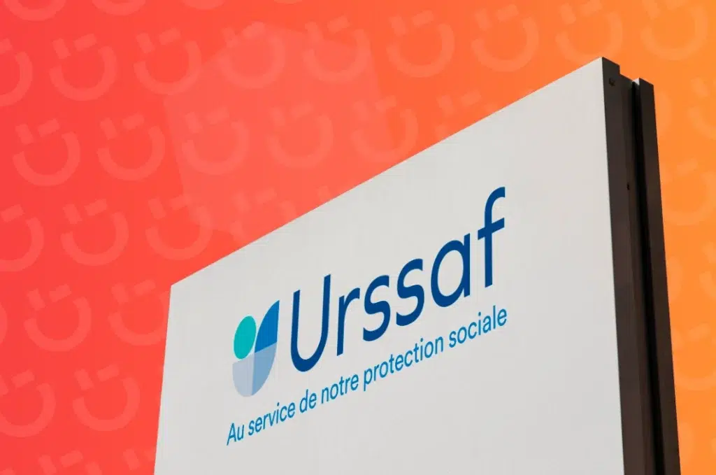 Sign with Urssaf logo and slogan 'Au service de notre protection sociale' on an orange background.